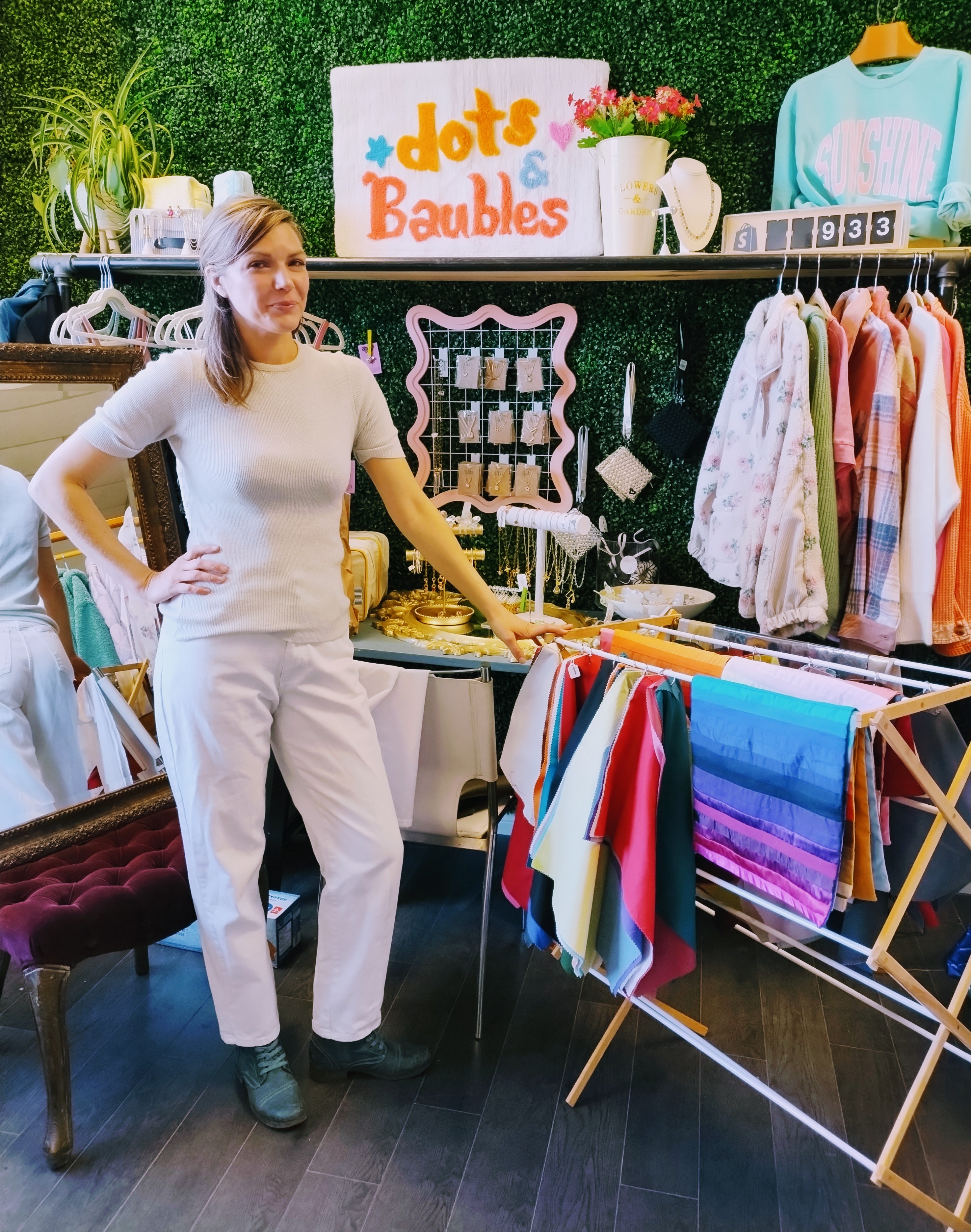 Krista standing in a boutique during a Glow Blossom host event with colour drapes displayed